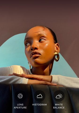 A person with their head turned to the side, bright light shines on them from opposite direction, their hands overlapped on a flat surface in front of them at shoulder height, three photo controls: Lens Aperture, Histogram, and White Balance