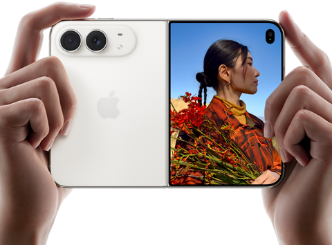 iPhone Duo, Star White color, held by two hands in horizontal orientation, unfolded, left panel shows 48MP Dual Fusion rear cameras, right panel shows person getting their picture taken on outer display, the subject of the photo is able to see their face as their picture is getting taken using Duo Preview